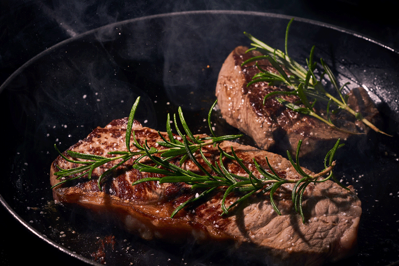 Steak and rosemary in a cast iron skillet